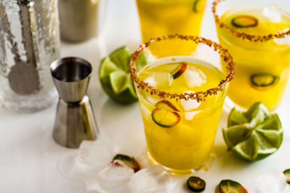 Mango and prosecco cocktail topped with jalapeno slice