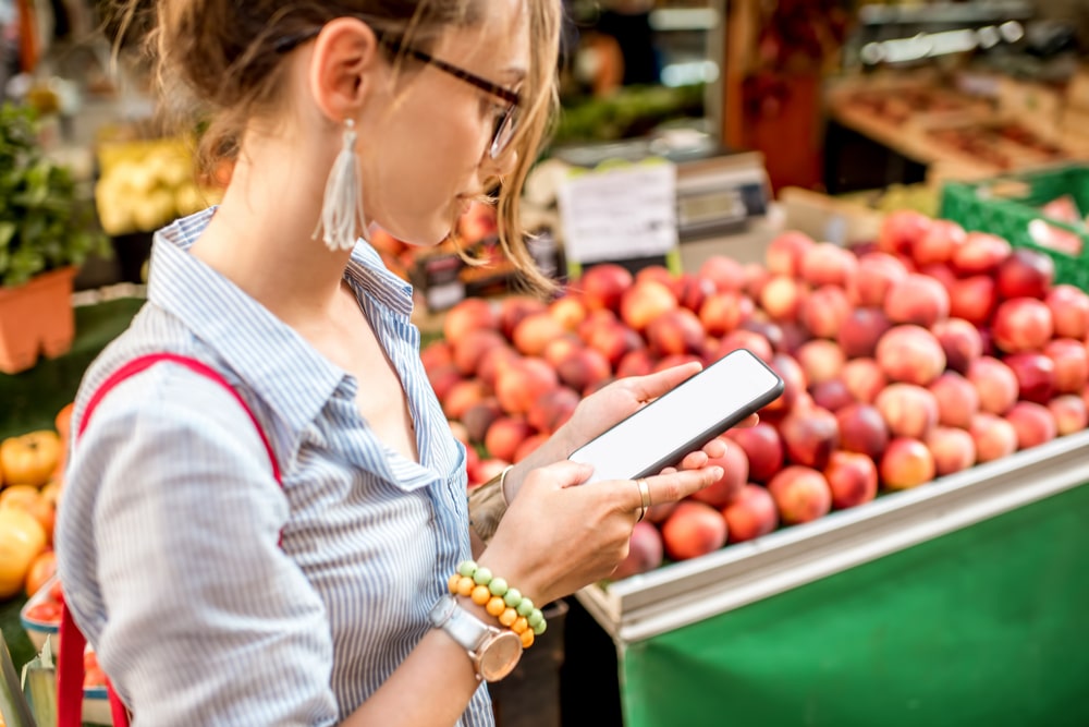 Woman reading grocery list on smartphone